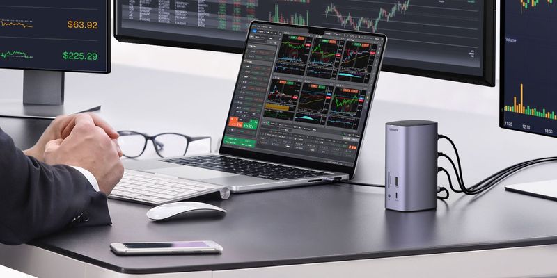 A closeup of a financial analyst working on their MacBook connected to an external display via Ugreen
