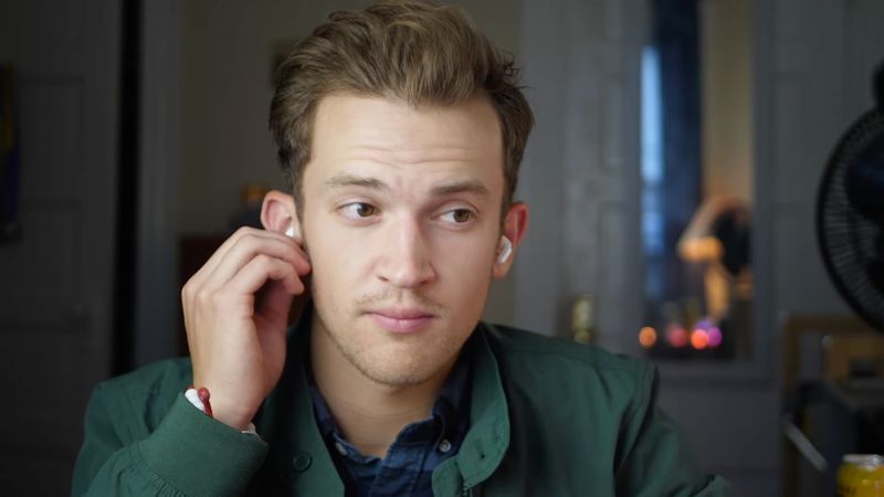 Young male putting second generation AirPods Pro 2 in their ears to listen to music