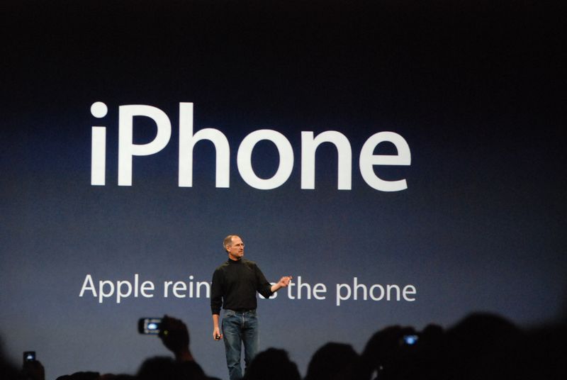 Steve Jobs standing in front of slide at the January 2007 iPhone introduction showing the tagline