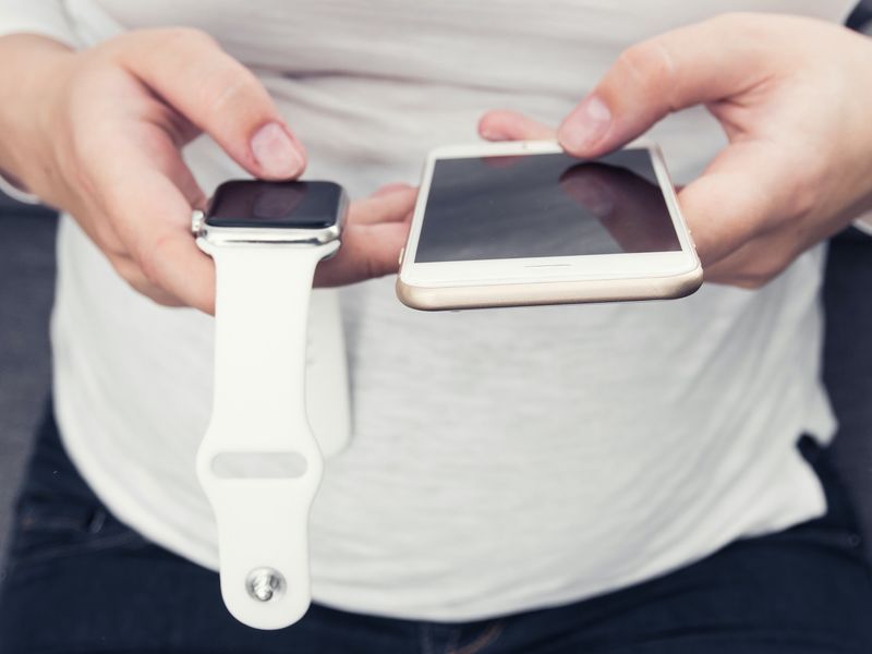 Holding an Apple Watch and iPhone