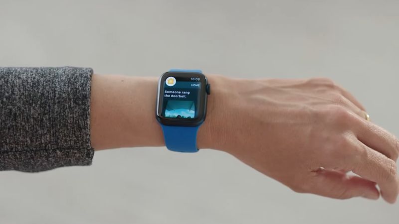 A photo showing a wrist with an Apple Watch running the Home app on watchOS 8 with the doorbell security camera video displayed on the screen