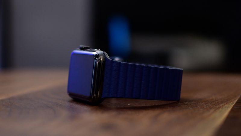 Apple Watch Series 3 avec boucle en cuir allongée sur le côté sur une table