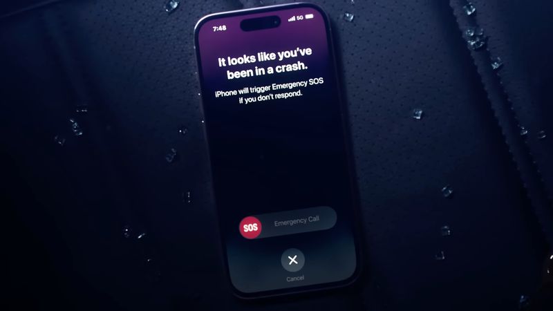 iPhone 14 Pro on a car seat surrounded by broken glass, displaying the Emergency SOS countdown timer