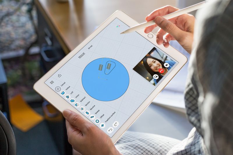 Promotional image showing a budget iPad held in one hand and Apple Pencil in another